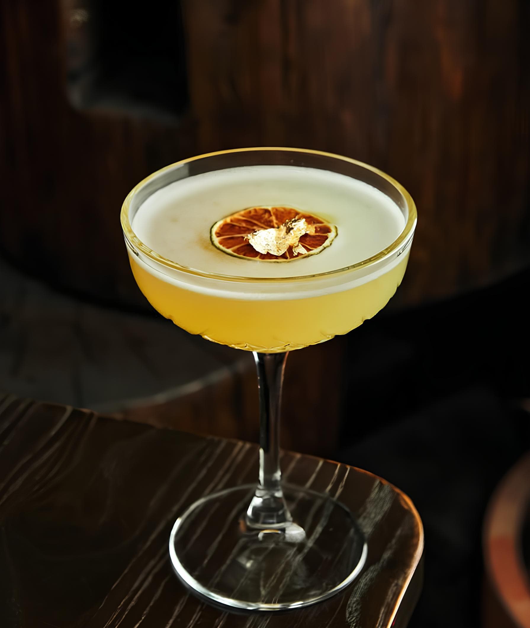 Golden citrus cocktail with dehydrated orange at the premium bar in Puerto Banús